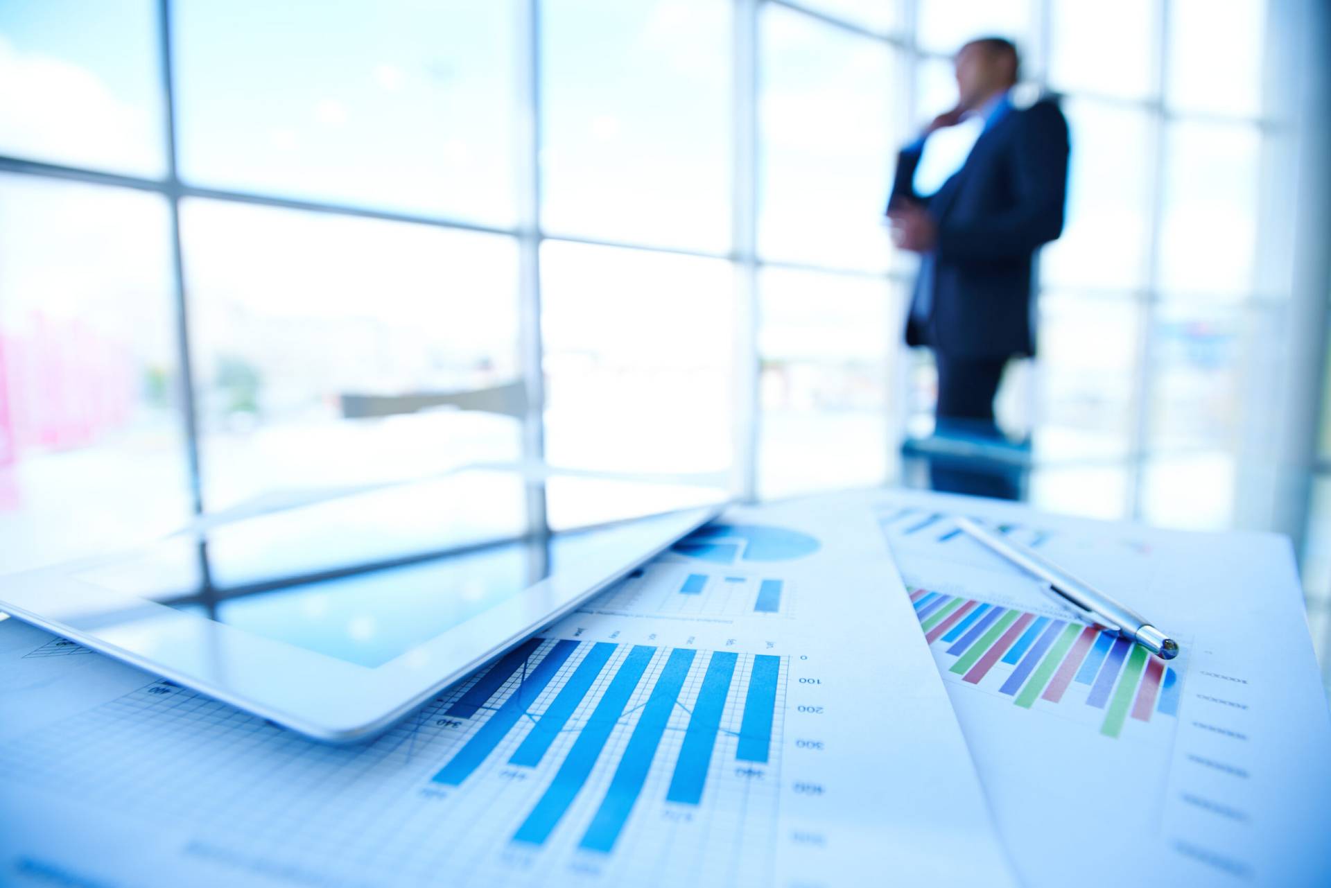 statistic documents desk with businessman scaled